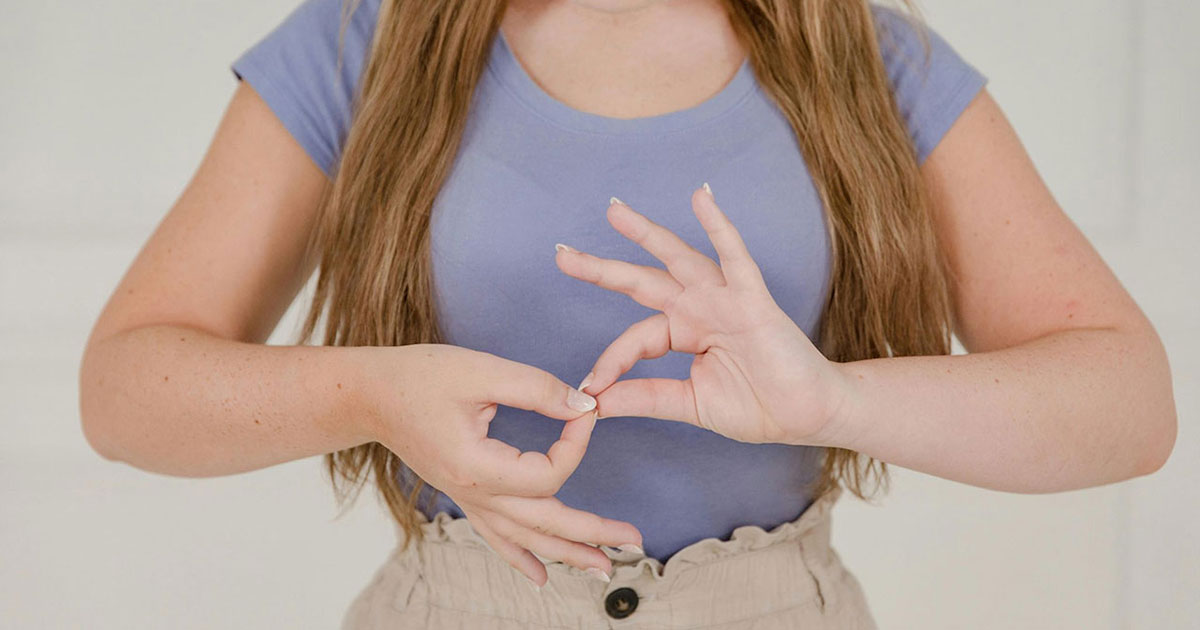 close up on womans hands while using sign language